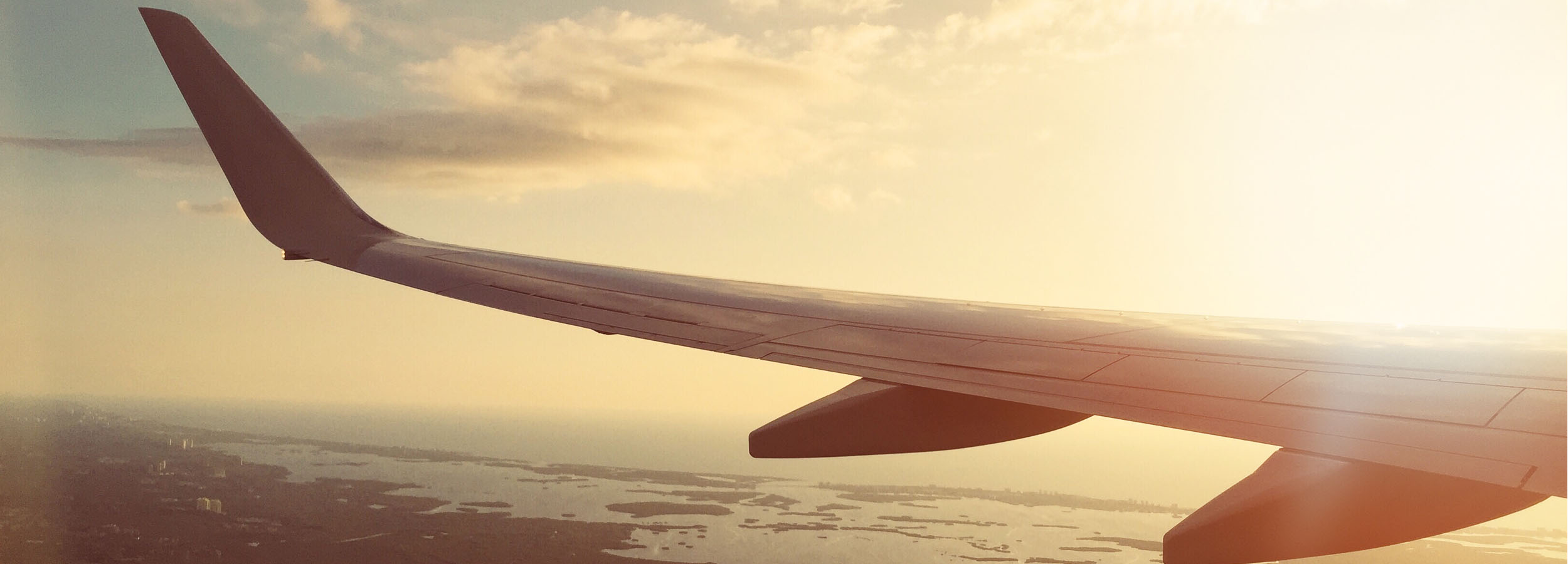 plane's wing against a sunset