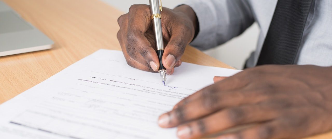 man signing document