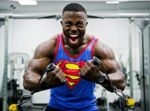 man wearing a superman shirt training weight training in gym