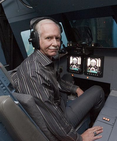 Captain Sully in the vertical motion simulator, wearing headphones and looking at the camera