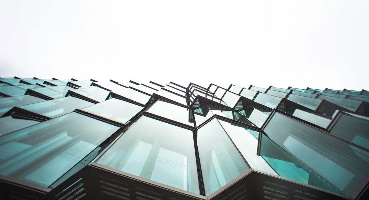 glass façade of building photographed from the bottom to the top.