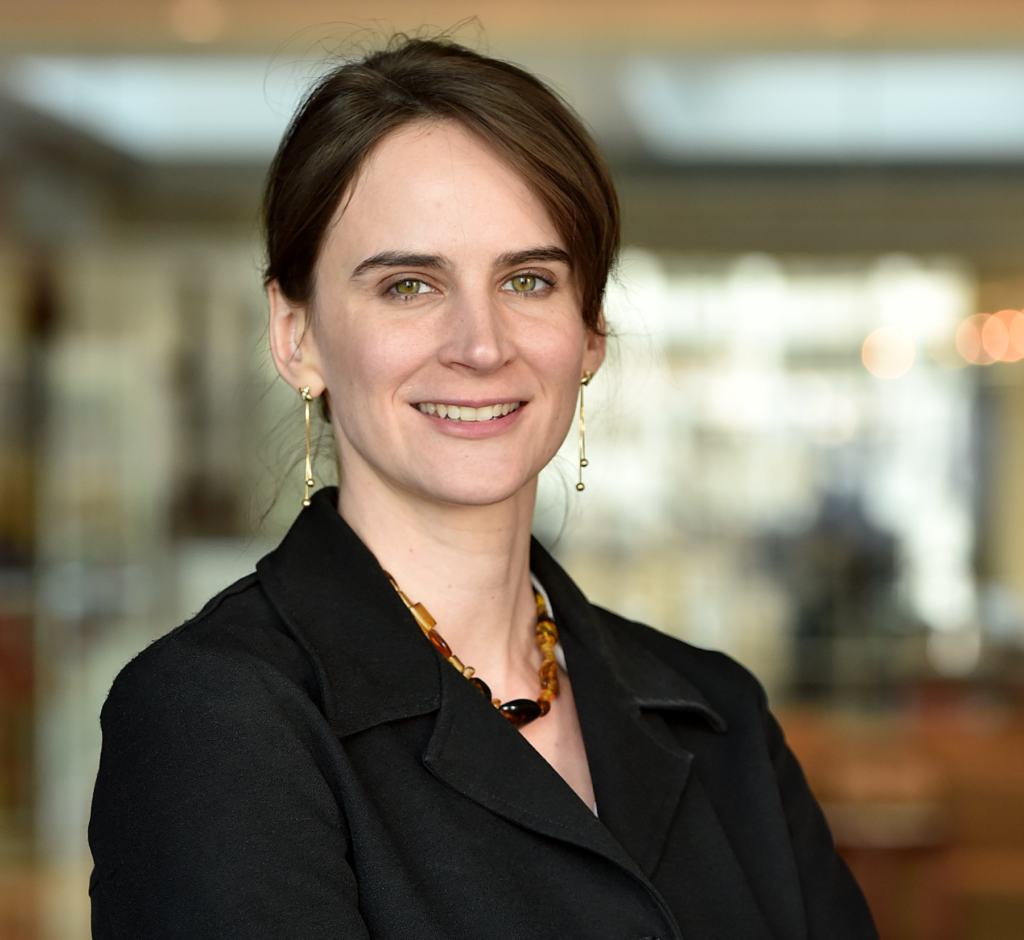 portrait of Tamber Hilton in a dark suit, soft smile, hair pulled back