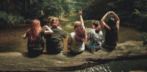 learning inpartof life, five girls sitting on a log