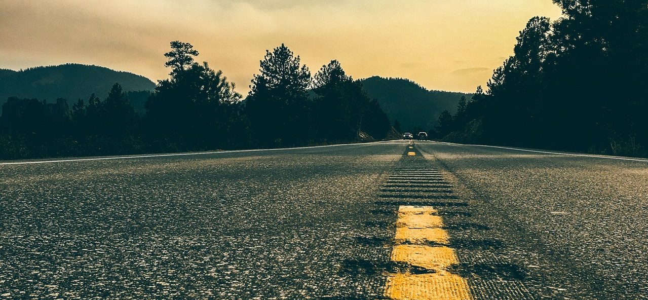 Asphalt covered road with mountains in the background