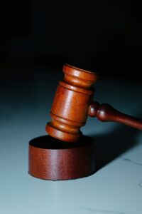 Wooden gavel resting on a table, partially raised.