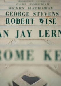 Close-up of multiple names painted on the slats of a bench, with 'Robert Wise' in focus