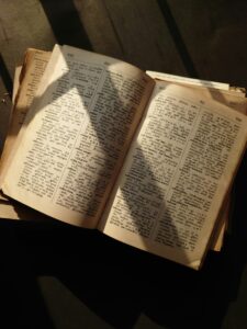 Open dictionary with sunlight and shadow casting across the pages.