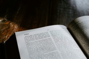 An open book titled "Ethics," resting on a wooden table, with soft lighting emphasizing the text