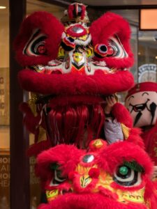 A vibrant red lion costume used in a traditional Lion Dance performance, symbolizing good fortune and prosperity, with intricate designs and vivid colors